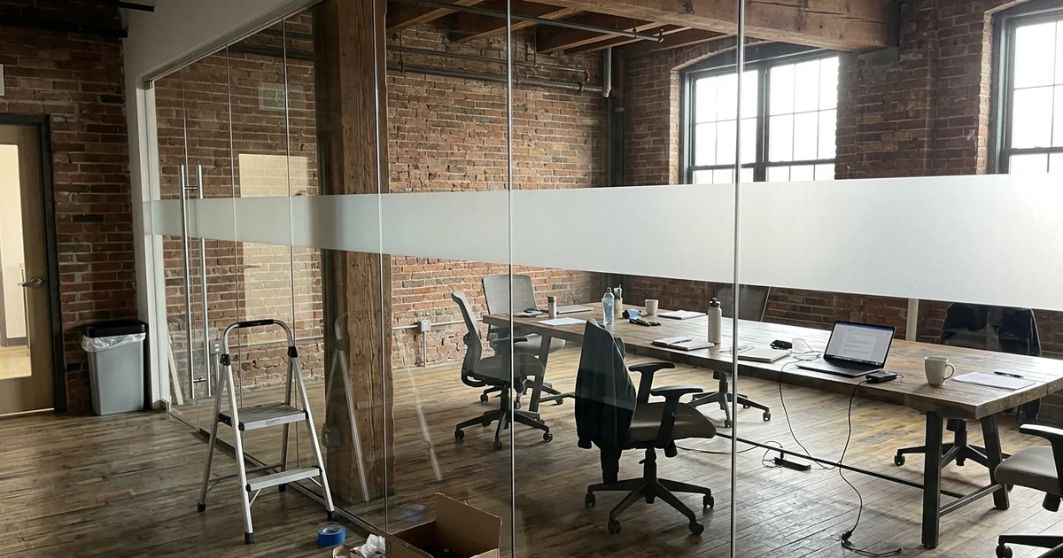 Boardroom glass wall with a new panel and matched frosted band in Liberty Village