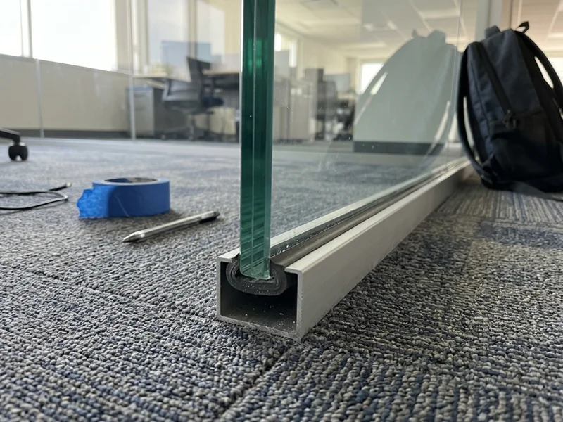 Partition glass set in an aluminium U-channel with dry glazing tape