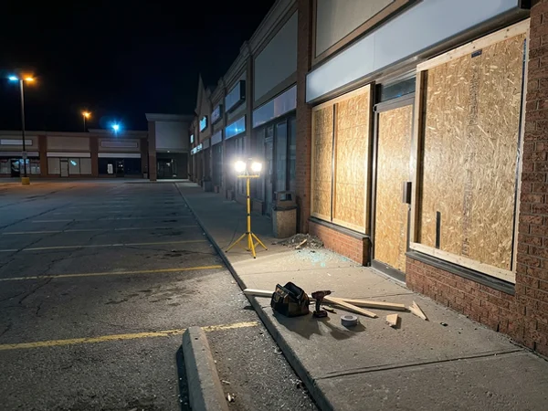 Agincourt plaza storefront boarded with OSB after a break-in