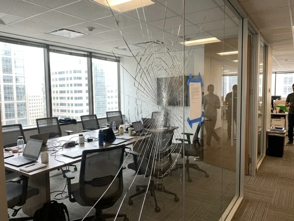 Cracked meeting room glass wall in a modern Toronto office