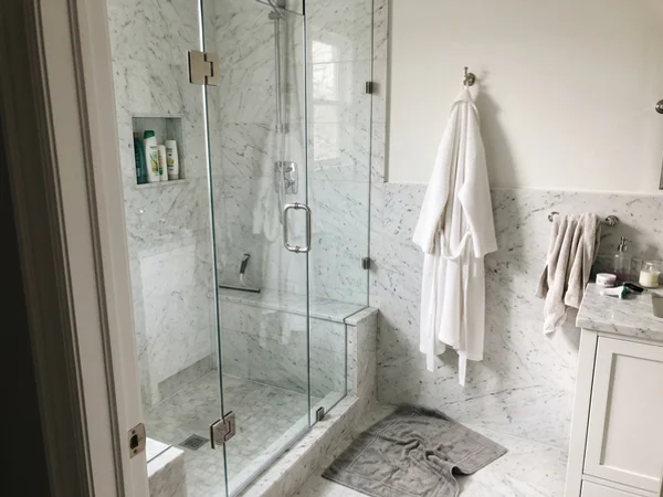 Starphire frameless shower with polished nickel hinges in Rosedale