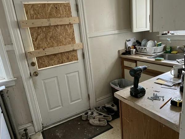 House back door boarded from inside with OSB and bracing