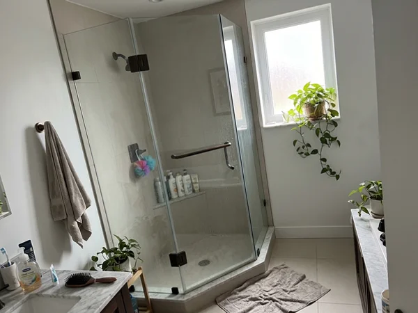 Neo-angle frameless shower with bronze patina hinges in a Yorkville condo