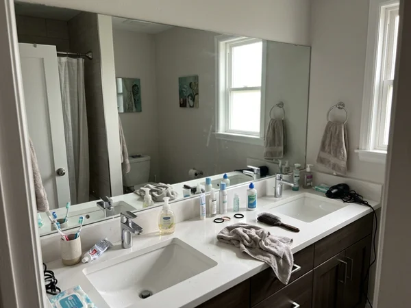 New wall-to-wall polished-edge vanity mirror in an Annex bathroom